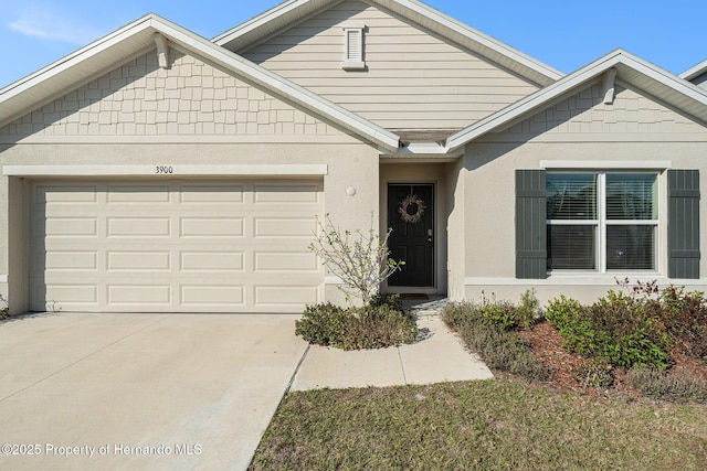 view of front facade with stucco siding, driveway, and a garage