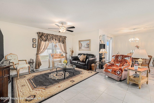 living area with light tile patterned floors, visible vents, ceiling fan with notable chandelier, and a textured ceiling