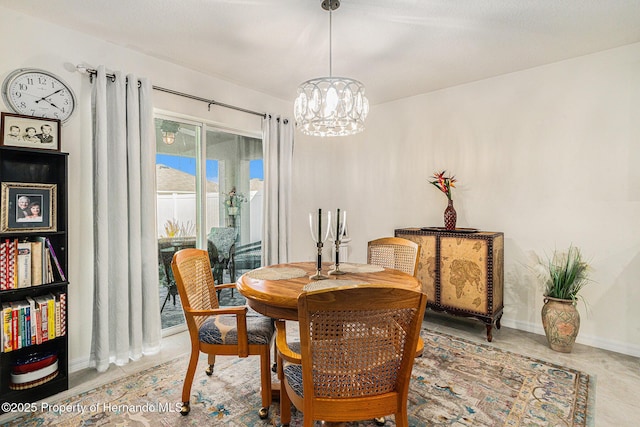 dining area featuring baseboards and a notable chandelier