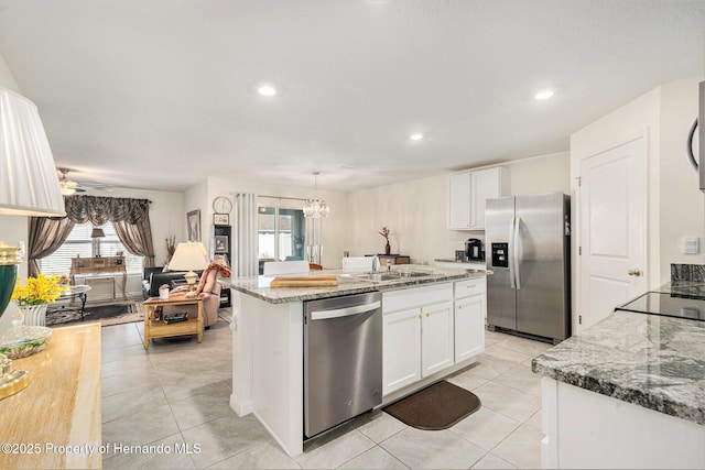 kitchen featuring a sink, stainless steel appliances, light tile patterned flooring, and white cabinetry