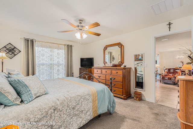 bedroom with tile patterned floors, visible vents, a textured ceiling, carpet, and ceiling fan