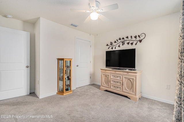 living area with light carpet, visible vents, baseboards, and a ceiling fan