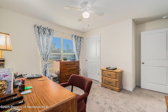 home office featuring baseboards, light colored carpet, a ceiling fan, and a textured ceiling