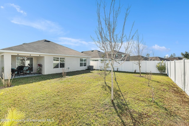 view of yard featuring a fenced backyard, central AC, and a patio