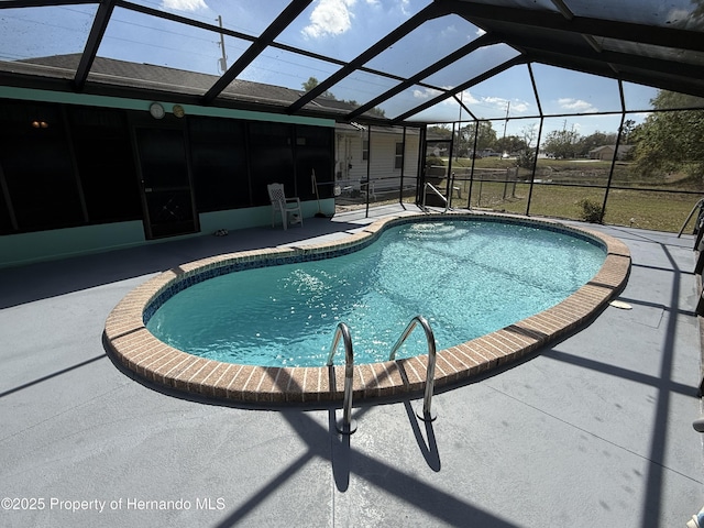 pool with glass enclosure and a patio