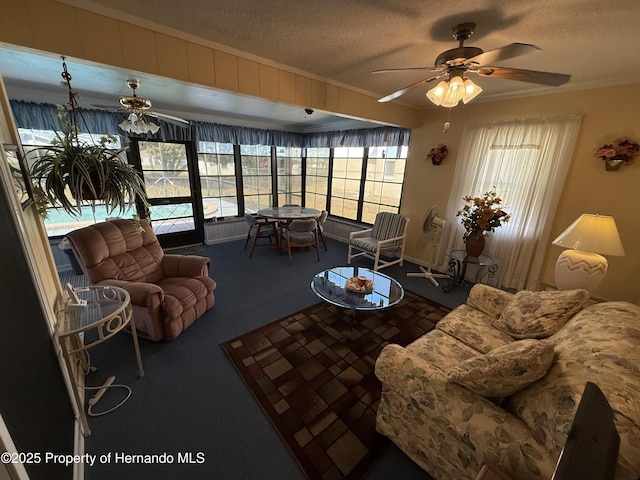 living room featuring ceiling fan, a textured ceiling, ornamental molding, and carpet flooring