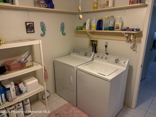 clothes washing area with laundry area, light tile patterned floors, and washing machine and dryer