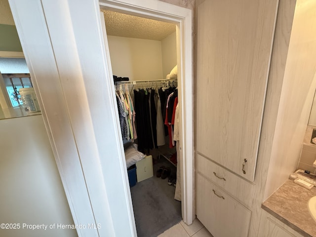 spacious closet with light tile patterned floors