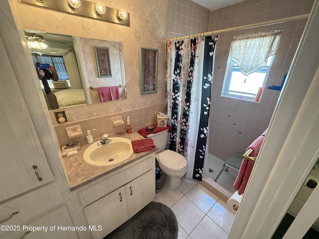 full bath with toilet, a stall shower, tile walls, tile patterned flooring, and vanity