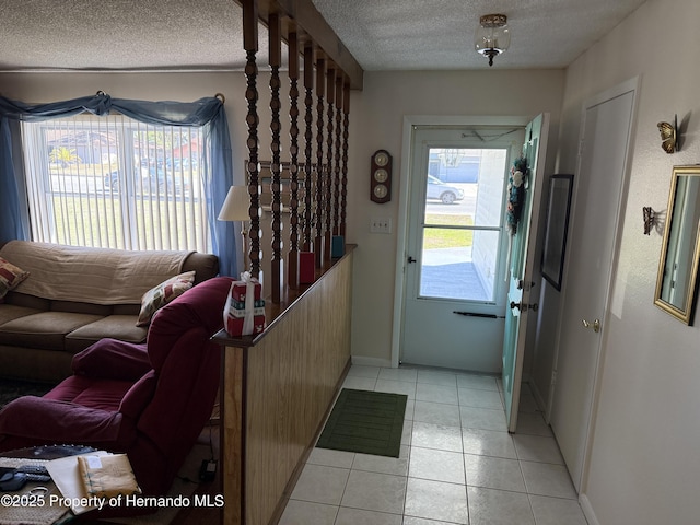 entrance foyer with light tile patterned floors, baseboards, and a textured ceiling