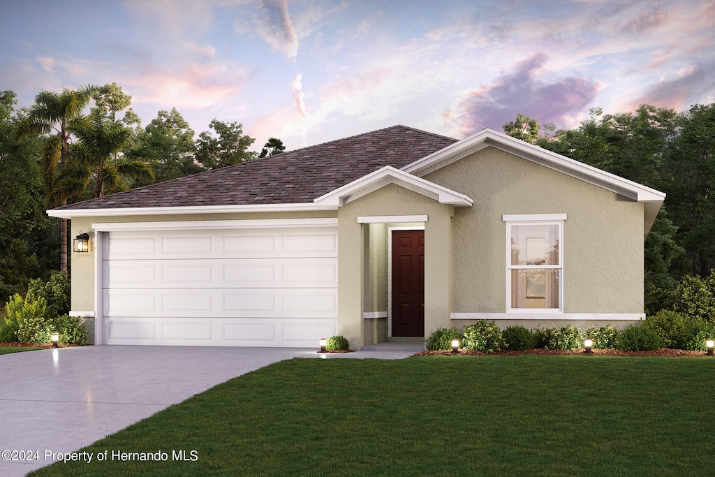 ranch-style home with stucco siding, a yard, concrete driveway, a shingled roof, and a garage