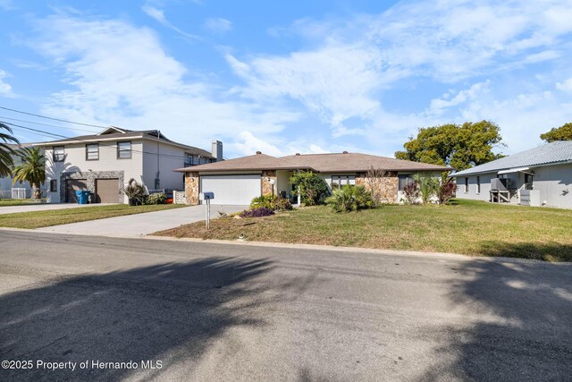 view of front facade with a front lawn, concrete driveway, and an attached garage