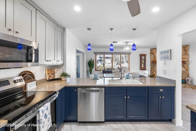 kitchen featuring a sink, a peninsula, appliances with stainless steel finishes, and ceiling fan