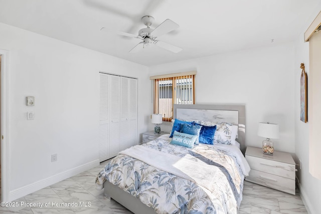 bedroom featuring a closet, baseboards, marble finish floor, and a ceiling fan