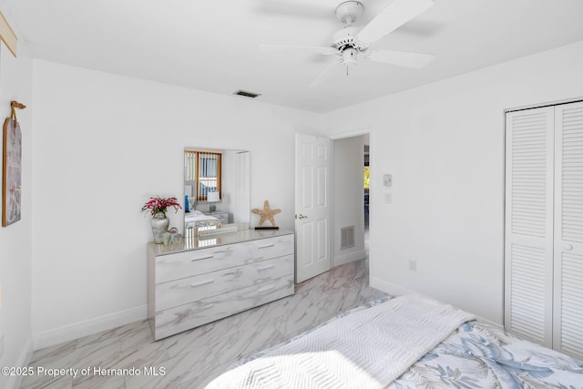 bedroom featuring a closet, visible vents, marble finish floor, and baseboards