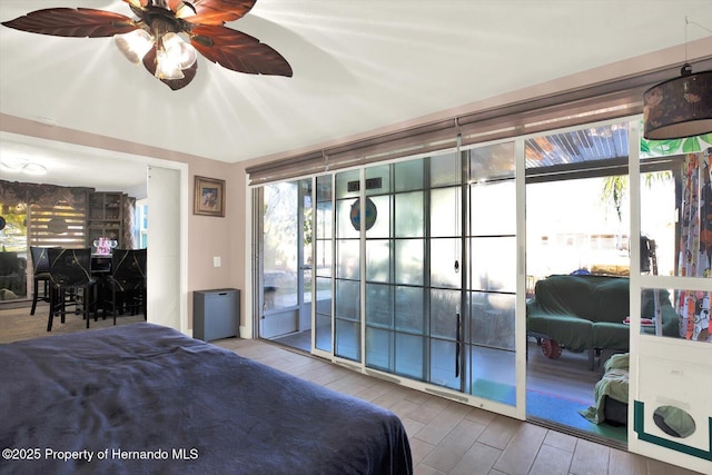 bedroom featuring ceiling fan, wood finished floors, and access to outside