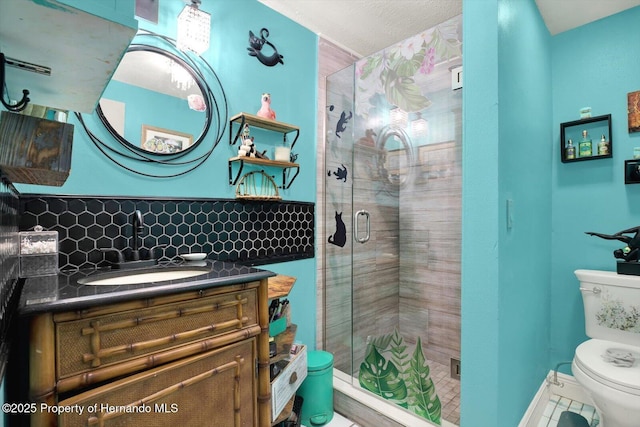 bathroom with toilet, a stall shower, decorative backsplash, baseboards, and vanity