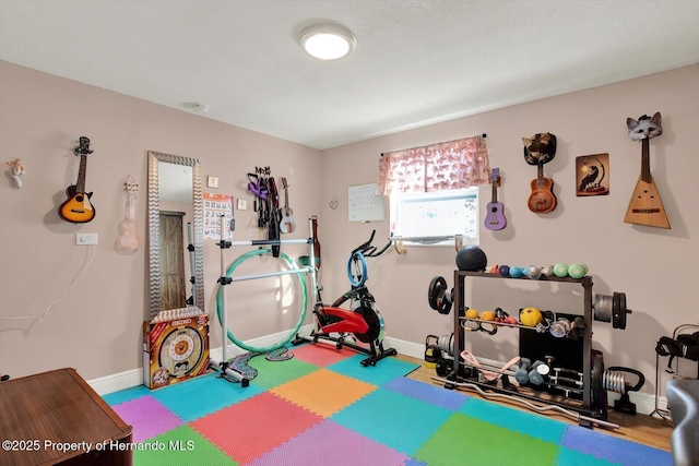 workout room featuring baseboards