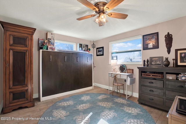 bedroom featuring light wood-style floors, baseboards, and ceiling fan