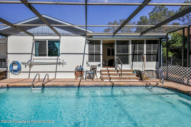 pool featuring a patio area and glass enclosure