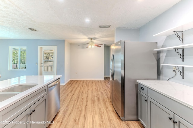 kitchen featuring visible vents, ceiling fan, gray cabinets, stainless steel appliances, and open shelves