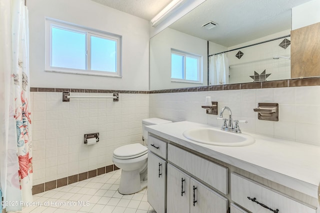 full bathroom featuring tile patterned flooring, visible vents, toilet, vanity, and a textured ceiling