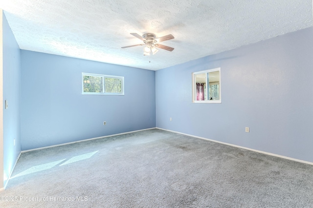 spare room with baseboards, carpet flooring, a textured ceiling, and a ceiling fan