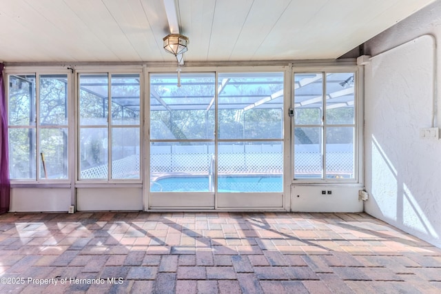 unfurnished sunroom featuring plenty of natural light and wooden ceiling