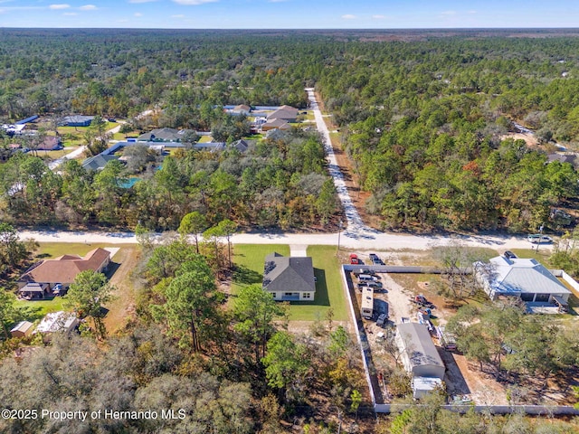 drone / aerial view with a wooded view