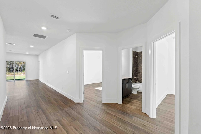 empty room with visible vents, recessed lighting, baseboards, and wood finished floors