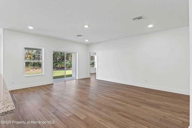 spare room featuring visible vents, recessed lighting, baseboards, and wood finished floors