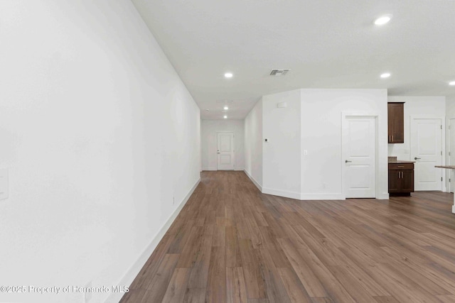 empty room featuring recessed lighting, visible vents, baseboards, and wood finished floors