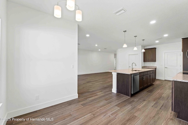 kitchen featuring visible vents, a sink, dark wood-type flooring, dark brown cabinets, and stainless steel dishwasher