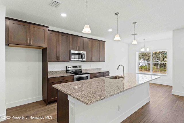 kitchen with visible vents, dark brown cabinetry, appliances with stainless steel finishes, wood finished floors, and a sink