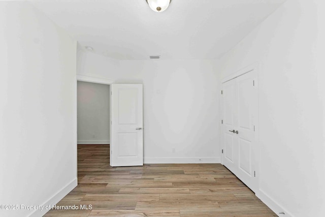 spare room with light wood-style flooring and baseboards