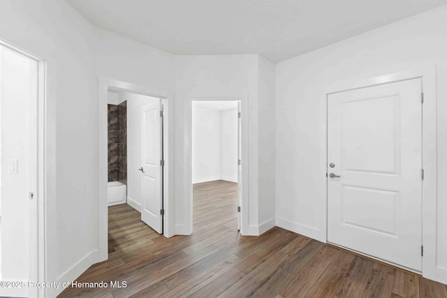 interior space featuring baseboards and wood finished floors