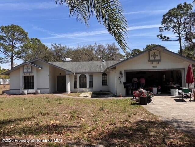 rear view of house featuring a garage, a yard, and driveway