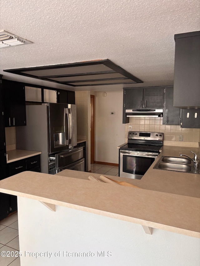 13935 Linden Dr, Spring Hill, FL 34609 - kitchen featuring a sink, a textured ceiling, light tile patterned floors, and stainless steel appliances
