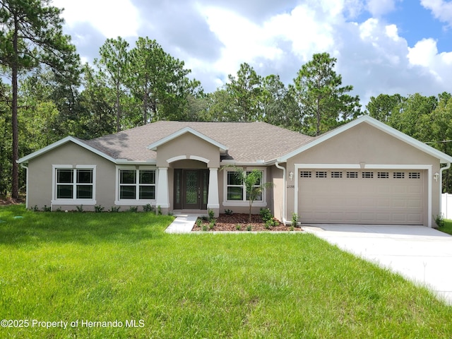 ranch-style house featuring a shingled roof, a front yard, stucco siding, a garage, and driveway