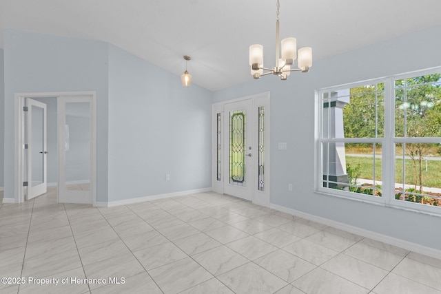 spare room featuring a chandelier, french doors, lofted ceiling, and a wealth of natural light