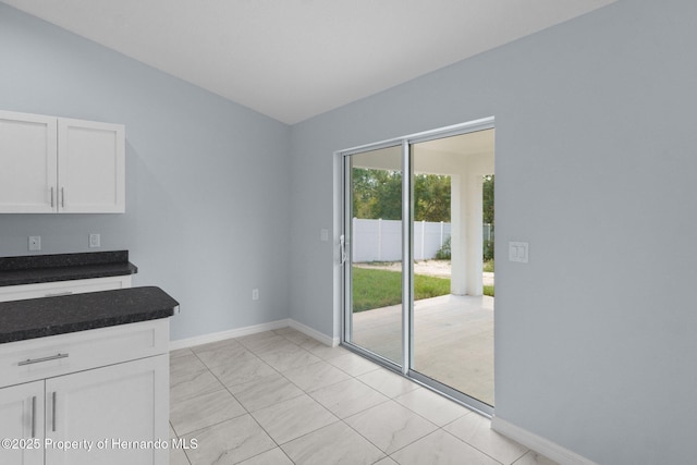 unfurnished dining area featuring baseboards