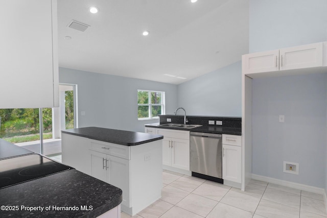 kitchen featuring dark countertops, visible vents, stainless steel dishwasher, white cabinets, and a sink