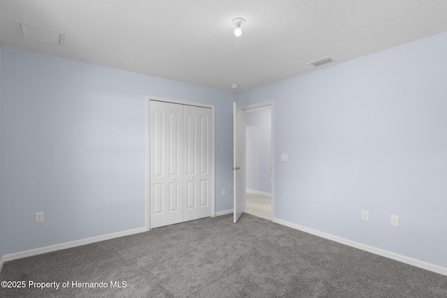 unfurnished bedroom featuring a closet, visible vents, carpet flooring, and baseboards