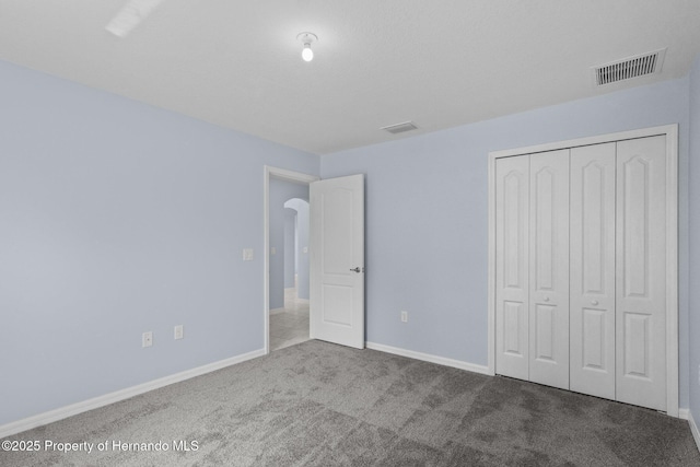 unfurnished bedroom with visible vents, baseboards, and carpet