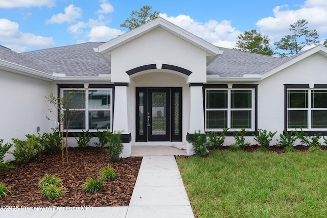 property entrance with roof with shingles and stucco siding