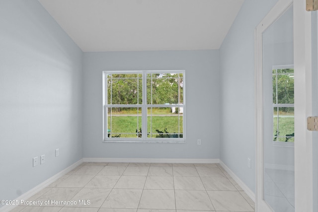 unfurnished room with a healthy amount of sunlight and baseboards