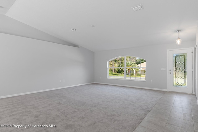 unfurnished living room with tile patterned floors, visible vents, carpet floors, baseboards, and vaulted ceiling