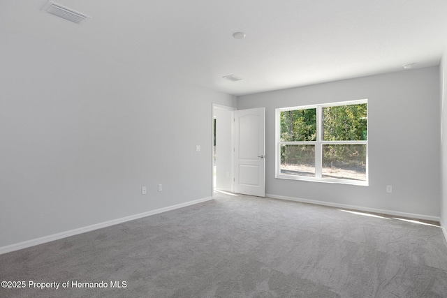 unfurnished room featuring visible vents, baseboards, and carpet