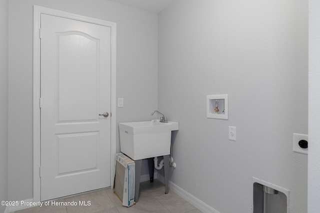 washroom with light tile patterned floors, baseboards, hookup for an electric dryer, laundry area, and washer hookup