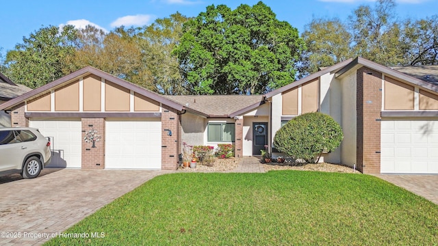 view of front of house featuring decorative driveway, brick siding, a garage, and a front lawn